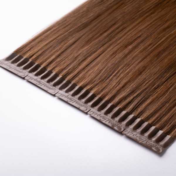 Brown hair extensions laid flat on a white surface.