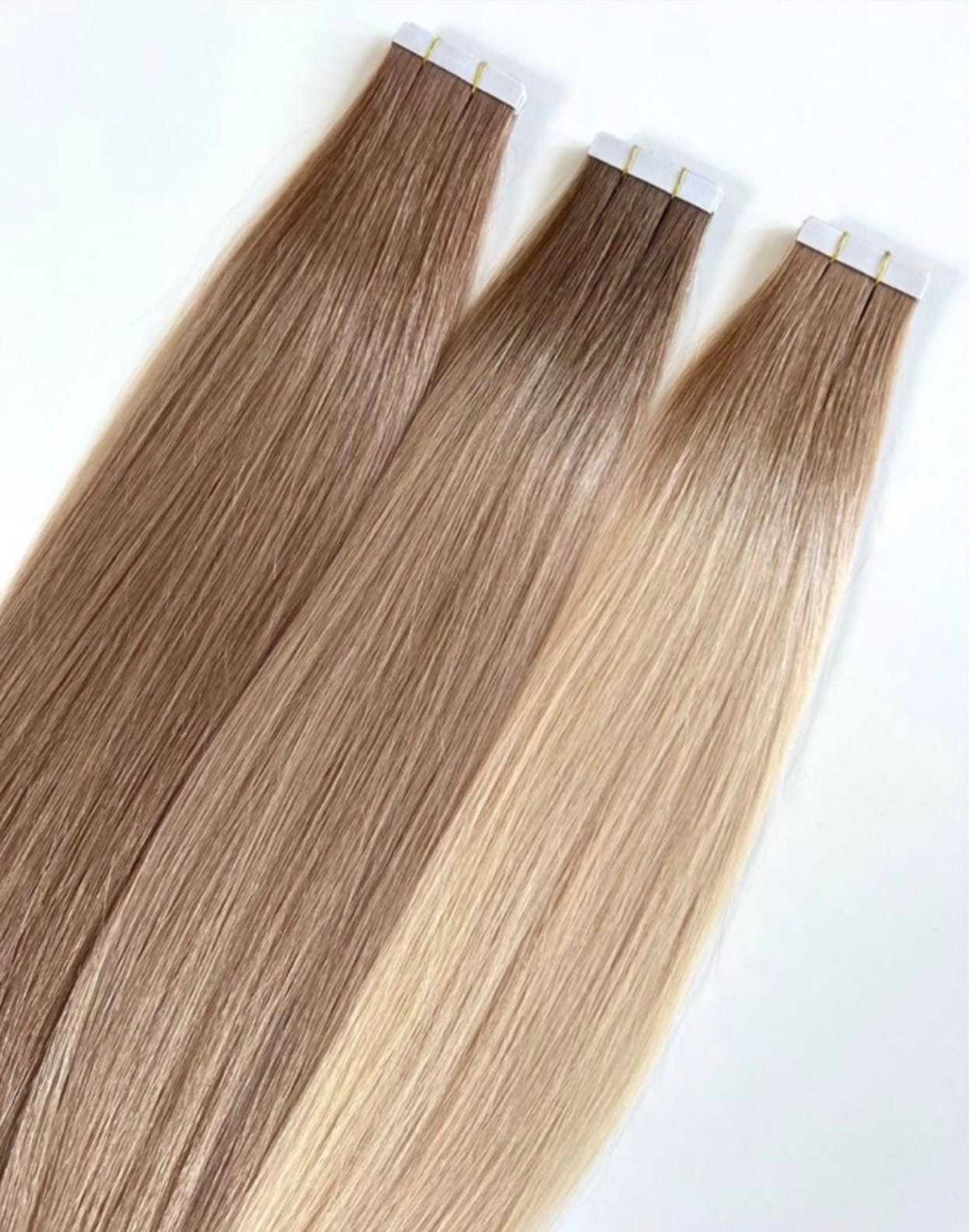 Three hair extension clips in varying shades of blonde and brown on a white background.